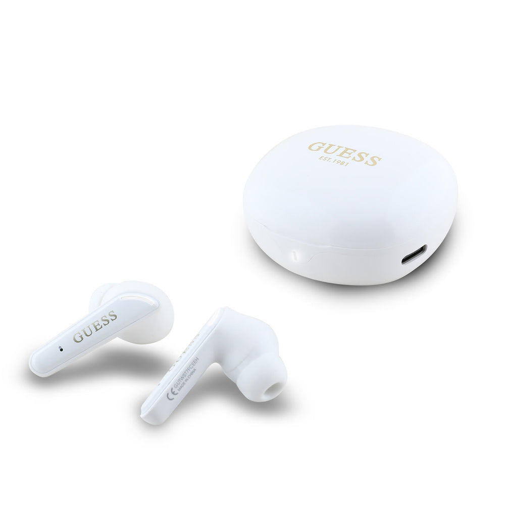 Witte Guess oordopjes naast witte oplaadcase met goudkleurig logo