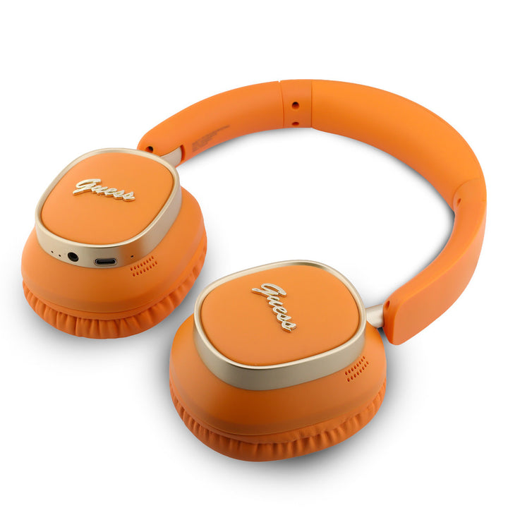 Oranje Guess koptelefoon liggend met oorschelpen naar boven